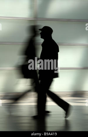 Silhouettes of two people passing by Stock Photo