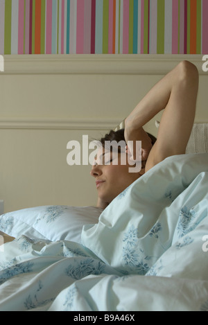 Young woman waking up in bed Stock Photo