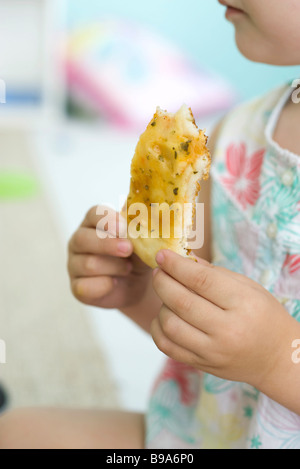 Child eating slice of pizza, cropped view Stock Photo