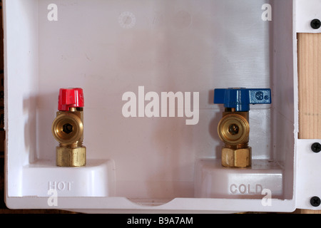 Hot and cold faucets in modern laundry room plumbing fixture Stock Photo