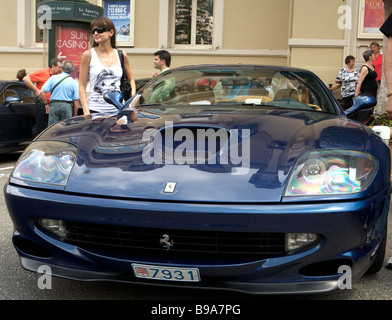 Blue Ferrari parked outside the Hotel du Paris, Monaco, Monte Carlo, with tourists posing for pictures with it. Stock Photo