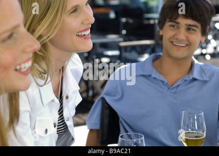 Three young friends sitting at a sidewalk cafe Stock Photo