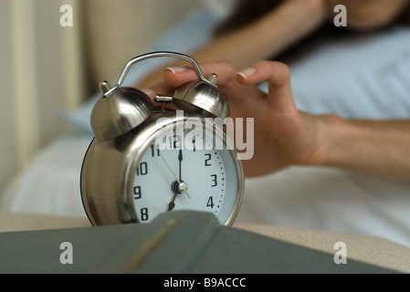 Woman's hand silencing alarm clock Stock Photo