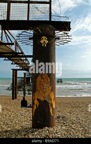 A face representing Jesus Christ spray painted on the rusty remains of the West Pier, Brighton, Sussex, UK. Stock Photo