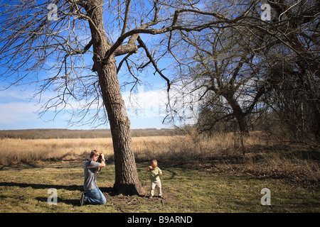 A teen photographer focuses on an oblivious two year old boy at the Tallgrass Prairie Reserve near Pawhuska, Oklahoma. Stock Photo