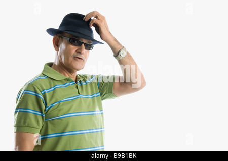 Man wearing sunglasses and holding hat Stock Photo