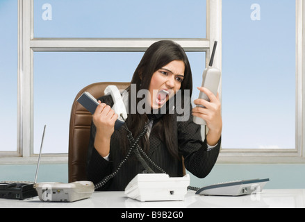 Stressed businesswoman shouting over telephone Stock Photo
