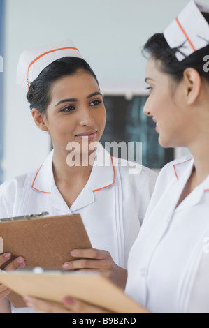 Two female nurses holding clipboards and smiling Stock Photo
