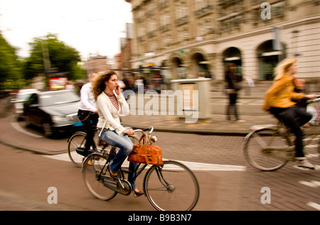 Woman talking on mobile-phone whilst cycling in Amsterdam Holland Stock Photo