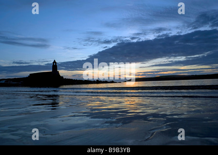 Sunset at Port Logan in Dumfries and Galloway, South-West Scotland, UK with the church silhouetted. Stock Photo