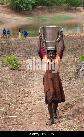 West africa Northern Ghana Larabanga young girls carrying buckets of water on the head Stock Photo