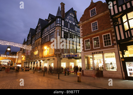 City of Chester, England. Night view of a busy shopping Christmas scene at Chester’s Eastgate Street. Stock Photo