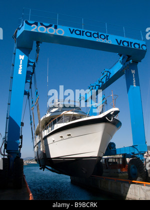 Semi displacement motor yacht on travel lift being put back into the water Stock Photo