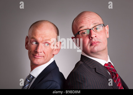 Portrait of two businessmen standing back to back Stock Photo