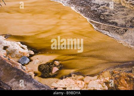 oil pollution on beach emulsified oil and water in surf. Pacific Adventurer disaster queensland 2009 Stock Photo