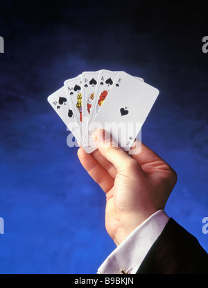 A male hand holding a royal flush, a straight flush to the ace, the ...