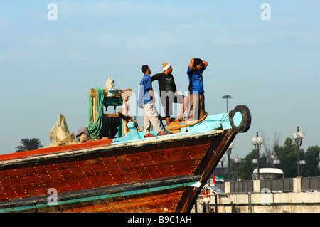 The crew of a traditional merchant ship watching the arrival in the Dhow port of Dubai, United Arab Emirates Stock Photo