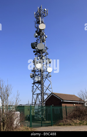 Tele communications mast with numerous Satellite dishes bolted onto the metal frame Stock Photo
