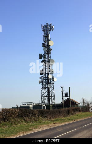 Tele communications mast with numerous Satellite dishes bolted onto the metal frame Stock Photo