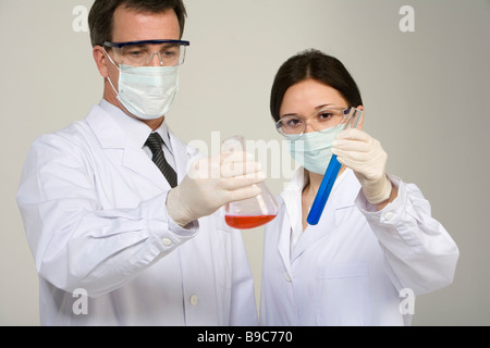Scientists examining liquids in beakers Stock Photo