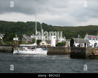 A yacht entering the sea lock, by the canal office, at the start of the Caledonian Canal at Corpach, Fort William, Scotland Stock Photo