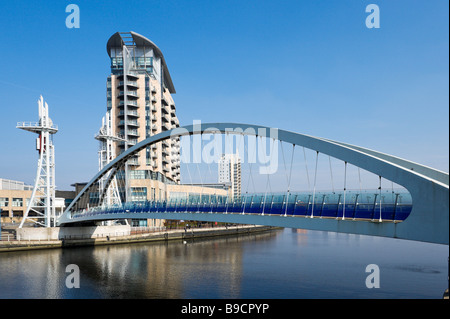 Modern flats behind the Millennium lifting footbridge over the Manchester Ship Canal, Salford Quays, Greater Manchester, England Stock Photo