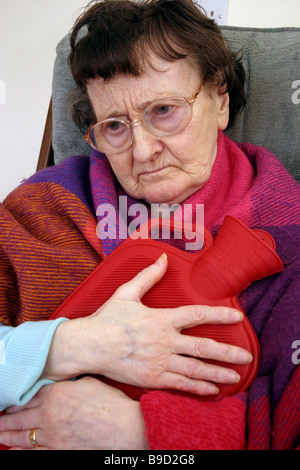 Older woman with dementia hugging hot water bottle Stock Photo