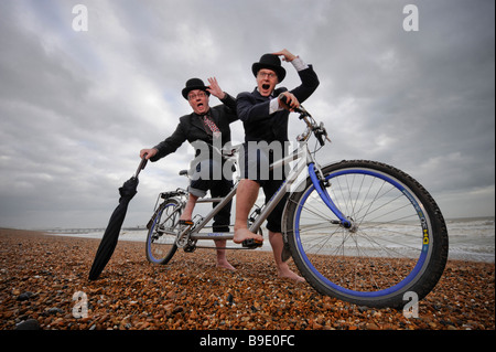 City gents limber up on Brighton beach with their tandem before competing in 'The Rat Race' event .