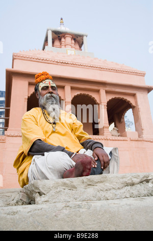 Sadhu sitting and praying in front of a temple, Varanasi, Uttar Pradesh, India Stock Photo
