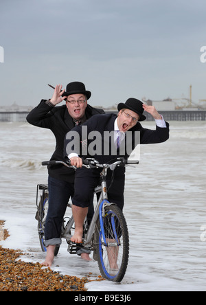 City gents limber up on Brighton beach with their tandem before competing in 'The Rat Race' event .