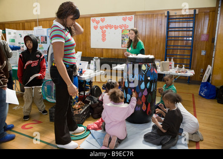 Kids paint a rain barrel learn about conservation at a Green Fair in Syracuse New York Stock Photo