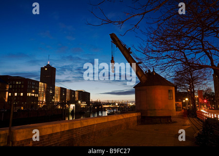 Crane on riverside at dusk, Hamburg, Germany Stock Photo