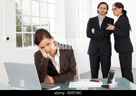 two businiss people talking about a third one Stock Photo