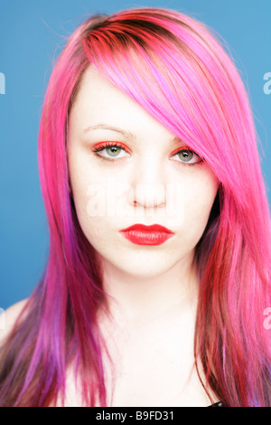 Young teen with bright pink hair and red lips looking straight at camera Stock Photo