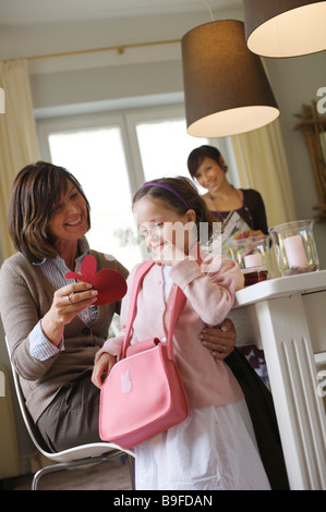 Woman giving present to her granddaughter at breakfast table