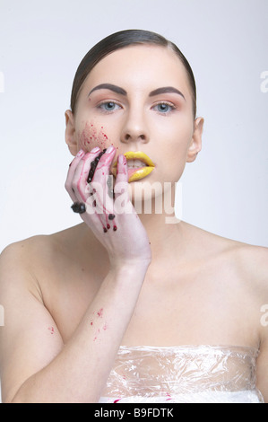 Portrait of young woman rubbing blueberries on her face Stock Photo