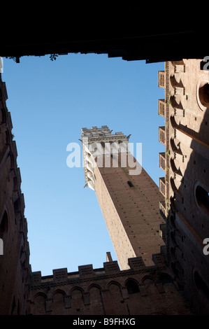 The view upwards to a blue sky from inside the La Torre del Mangia courtyard in Piazza del Campo Siena Italy Stock Photo