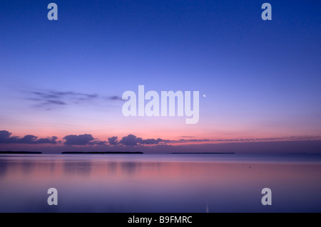 Moon sets as dawn lights mangrove islands in Florida Bay Everglades National Park Florida Stock Photo