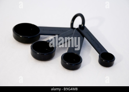 4 Measuring spoons in black plastic on a white background Stock Photo