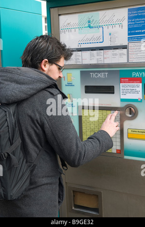 People buying tram tickets from a Manchester metrolink ticket machine ...