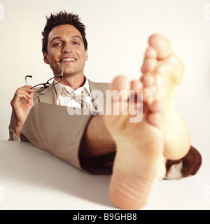 Managers barefoot feet puts up smiling  contentment series desk table people man 30-40 years glasses holding sitting  leans Stock Photo
