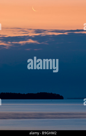 Moon sets as dawn lights mangrove islands in Florida Bay Everglades National Park Florida Stock Photo
