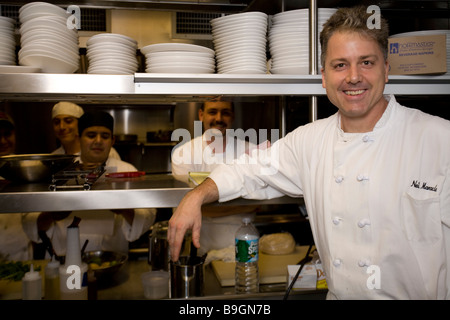 a chef in his kitchen with staff in background Stock Photo