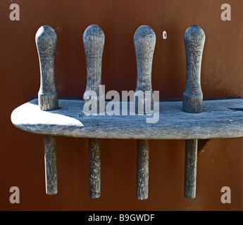 wooden pegs belaying pins used on tall-ship tall-ships in a holder four with orange mast background Stock Photo