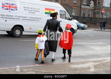 An orthodox Jewish man with two children dressed in fancy dress costumes for traditional festival of Purim,Stamford Hill London Stock Photo