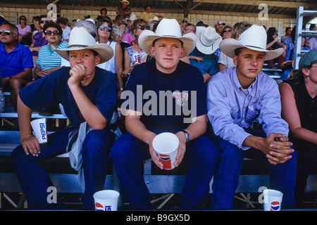 Three young cowboys sit in the grandstand watching the rodeo at the Mid States Fair in Paso Robles California Stock Photo