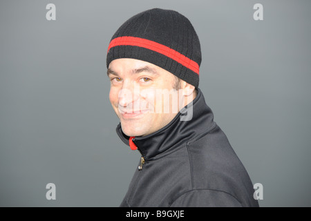 Young man with cap, looking into the camera, smiling Stock Photo