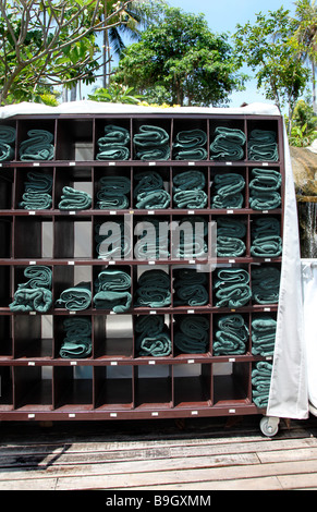 dark green towels tidied-up in the wood shelf near the swimming pool under the sun in thailand on holiday tourism tourist vaca Stock Photo