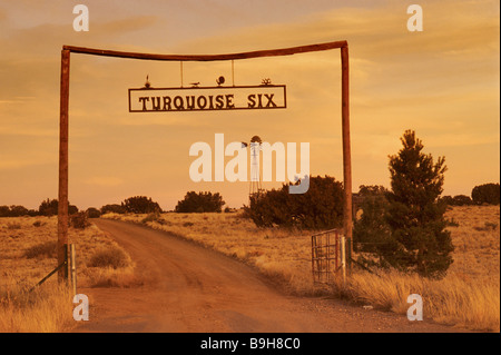 Wrought iron sign at timber ranch gate at sunset near Los Cerrillos on The Turquoise Trail in New Mexico, USA Stock Photo