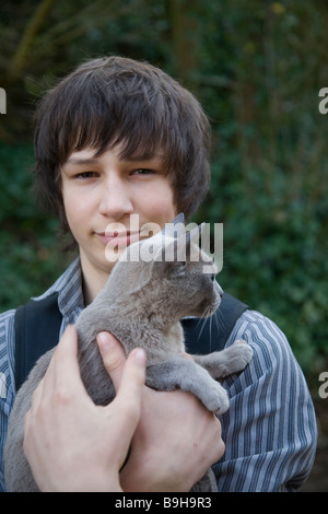 Model released portrait of teenage boy holding pet cat Stock Photo